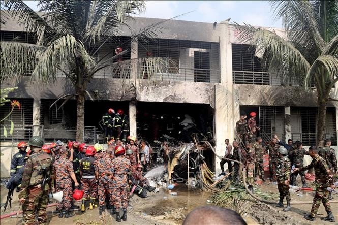 Binh sĩ và lính cứu hỏa Bangladesh làm nhiệm vụ tại hiện trường vụ rơi máy bay huấn luyện của Không quân nước này tại thủ đô Dhaka