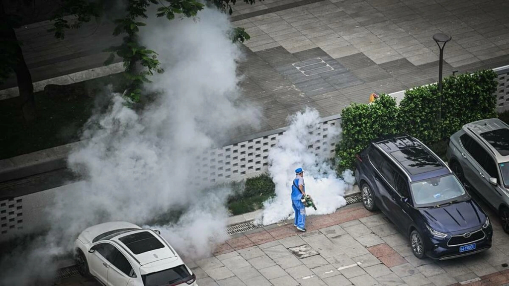 Nhân viên y tế phun thuốc diệt muỗi tại sân để xe của một tòa nhà ở Trung Quốc.