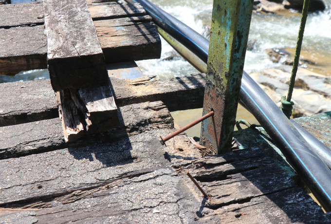 Cầu treo Hà Doi xuống cấp, nhiều vị trí ván gỗ cầu đã bị mục nát, đinh cầu bong tróc.