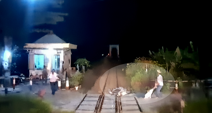 Khoảnh khắc anh Oánh (phải) lao ra cứu người khi tàu đã cận kề - Ảnh: Chụp lại màn hình