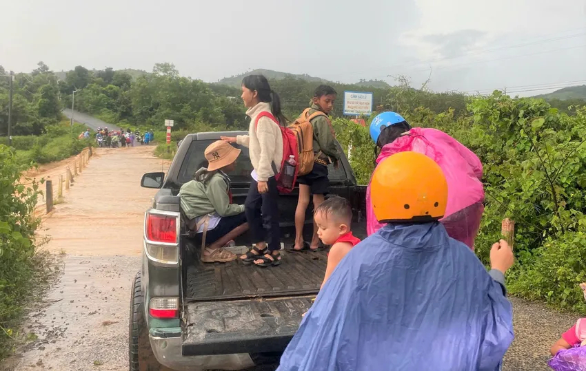 Học sinh đi học qua cầu tràn may mắn được một lái xe ô tô giúp đỡ qua cầu.