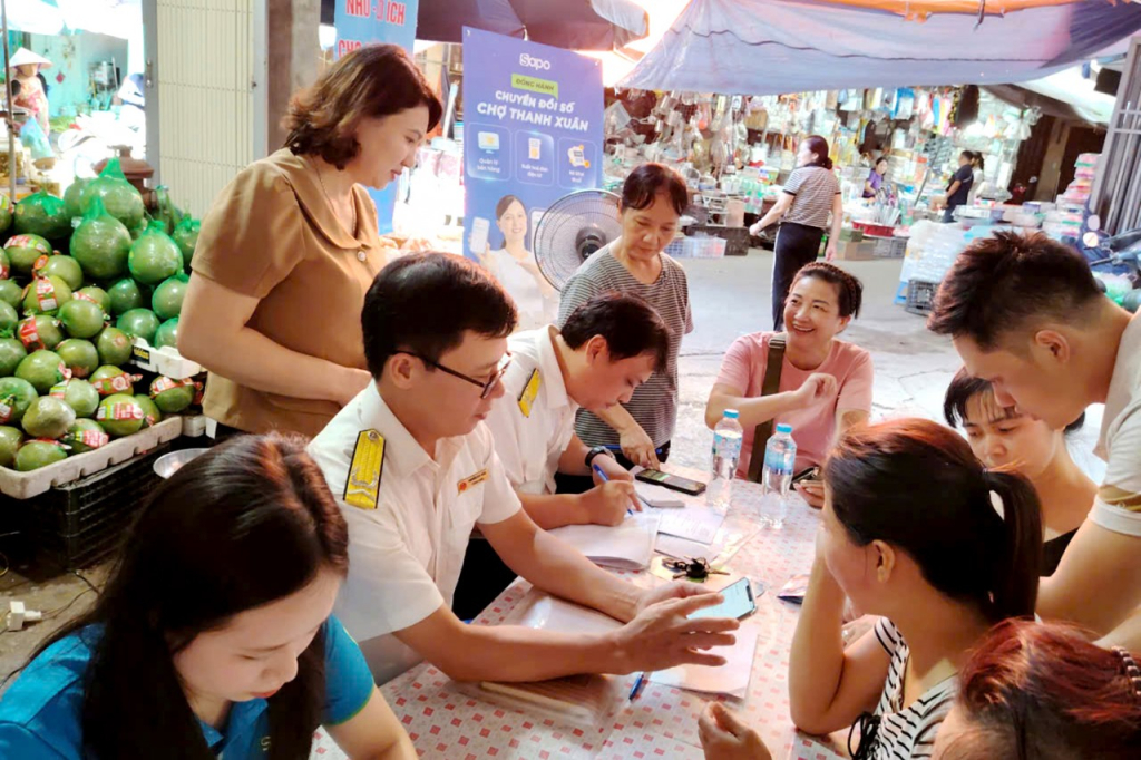 Công chức Thuế tuyên truyền, hỗ trợ hộ kinh doanh chuyển đổi sang phương pháp kê khai, nộp thuế. Ảnh: TL