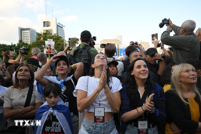 Người dân theo dõi chương trình truyền hình trực tiếp cuộc trao đổi con tin, tại quảng trường ở Tel Aviv, Israel ngày 13/10/2025. (Nguồn: THX/TTXVN)