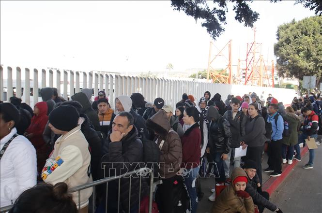 Người di cư xếp hàng tại điểm kiểm soát biên giới Chaparral ở Tijuana, Mexico. Ảnh: THX/TTXVN