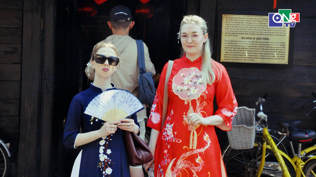 Một cặp đôi du khách nước ngoài chọn áo dài tông xanh thẫm, rạng rỡ giữa không gian rực rỡ của "thủ phủ" đèn lồng, tôn thêm vẻ đẹp đặc trưng và sức hút của phố Hội. Ảnh Trúc Ly