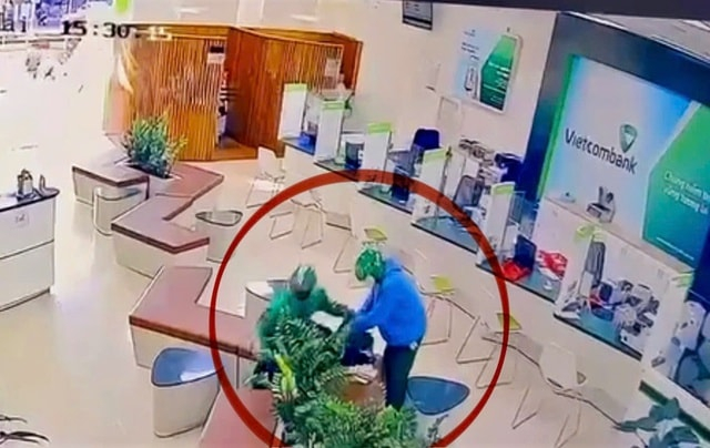 Hai đối tượng đang thực hiện hành vi cướp số tiền gần 2 tỷ đồng. Ảnh: cắt từ clip.