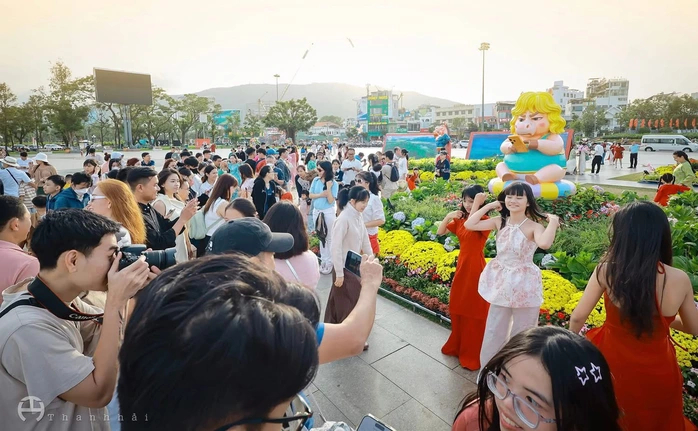 Nhiều bạn trẻ đổ xô check-in linh vật ngựa “mặt cộc” cầm điện thoại ở phố biển Quy Nhơn. Ảnh: Thanh Hải