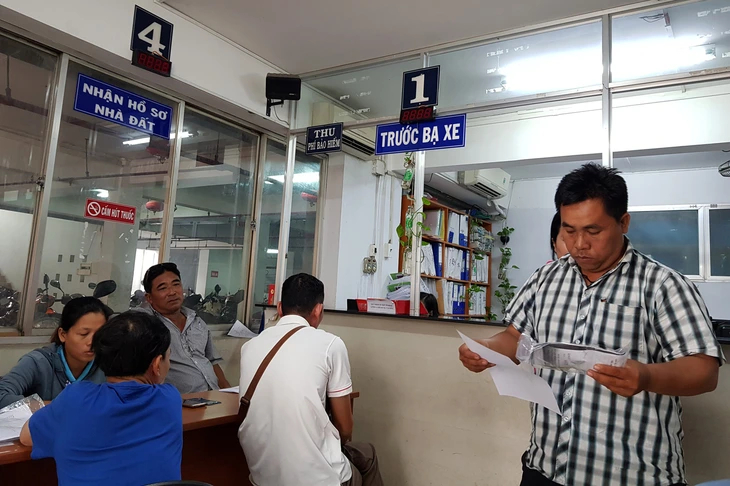 Người dân làm thủ tục đóng lệ phí trước bạ ô tô, xe máy - Ảnh: Ngọc Hiển