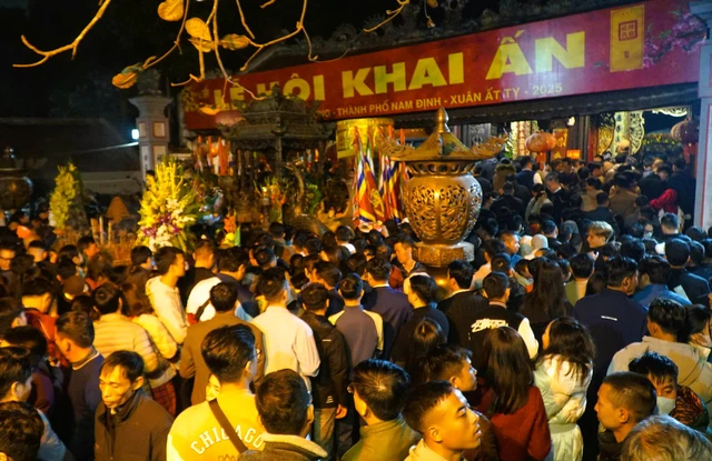 Người dân chen nhau trong khu vực các nhà đền sau lễ Khai ấn để dâng lễ, cầu may mắn.