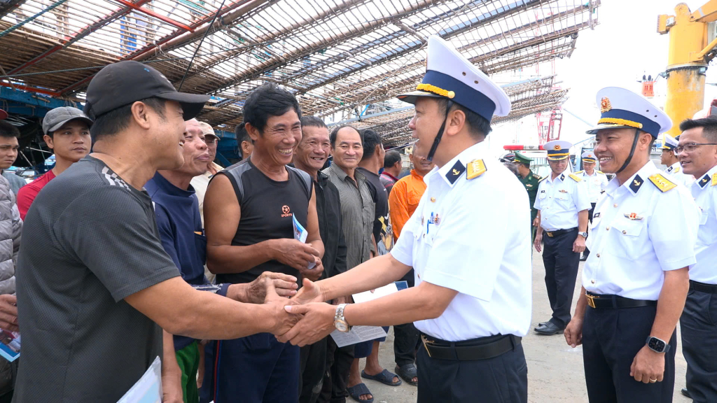 Đại tá Lương Xuân Giáp - Phó chủ nhiệm Chính trị Vùng 4 cùng đại diện cơ quan chức năng của đến động viên ngư dân cập cản. Ảnh: Vùng 4 Hải quân