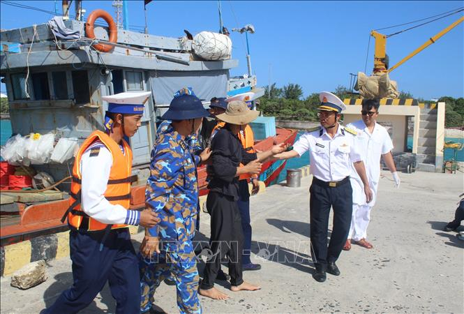 Đưa ngư dân gặp nạn vào đảo Song Tử Tây để điều trị gãy ngón tay do tai nạn lao động. Ảnh: TTXVN