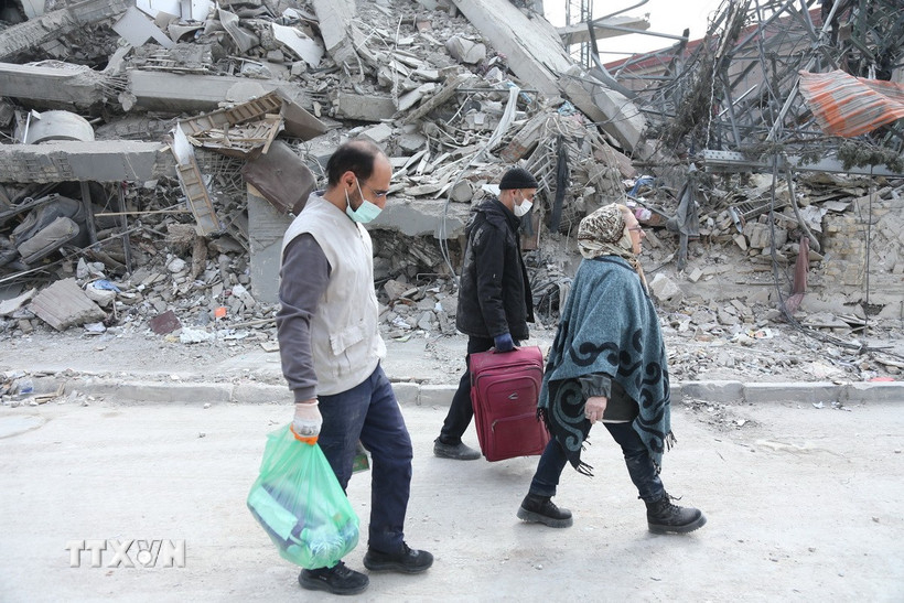 Người dân đi qua đống đổ nát của những tòa nhà bị phá hủy tại Tehran, Iran. Ảnh: THX/TTXVN