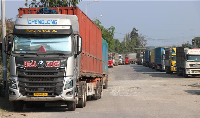 Dàn xe tải, xe đầu kéo biển số nhiều tỉnh nối đuôi nhau đậu đỗ hai chiều đường Quốc lộ 24C.