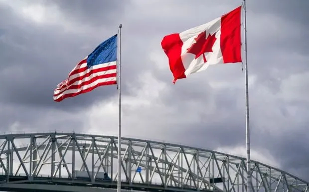Cờ Mỹ và Canada tại khu vực cửa khẩu Blue Water Bridge ở Point Edward, Ontario, ngày 24/10/2025. Ảnh: AFP