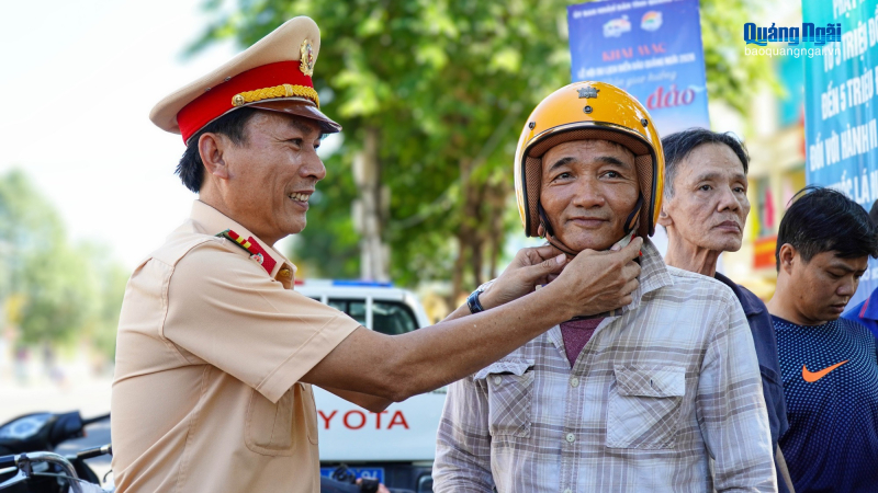 Cảnh s&aacute;t giao th&ocirc;ng Quảng Ng&atilde;i tặng mũ bảo hiểm cho người d&acirc;n 