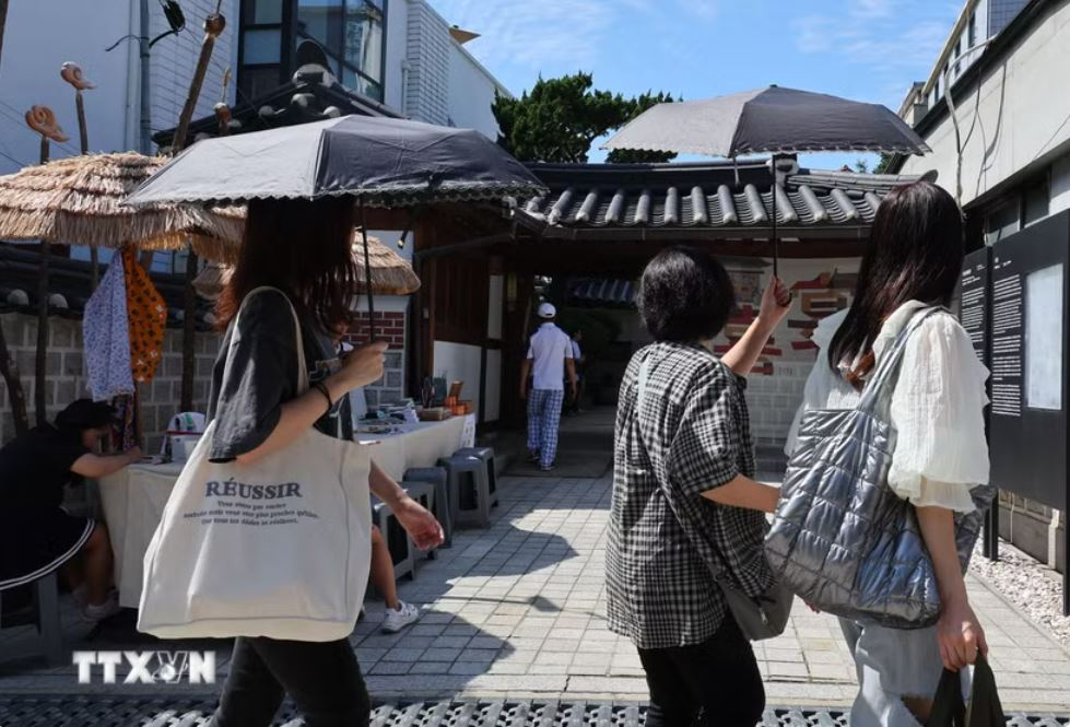 Người dân di chuyển dưới trời nắng nóng tại Seoul, Hàn Quốc. Ảnh: Yonhap/TTXVN