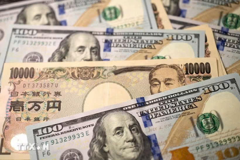 Đồng tiền 10.000 yen của Nhật Bản và đồng 100 USD. Ảnh: THX/TTXVN