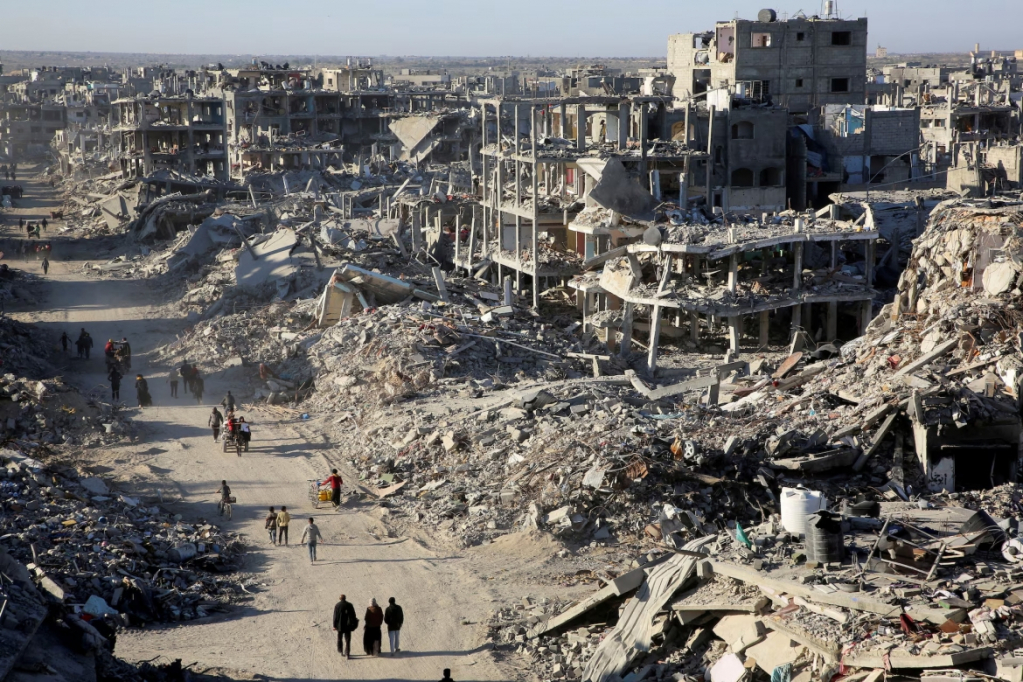 Người dân Palestine đi ngang qua đống đổ nát của những ngôi nhà và tòa nhà bị phá hủy trong chiến tranh, ở Rafah, phía nam Dải Gaza.