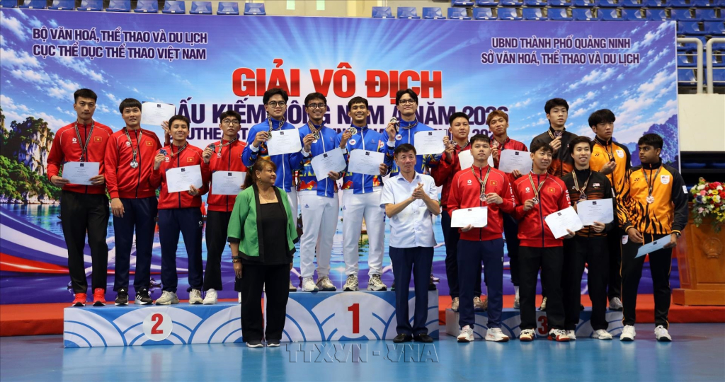Ban tổ chức trao giải cho các vận động viên ở nội dung đồng đội nam kiếm liễu. Ảnh: TTXVN